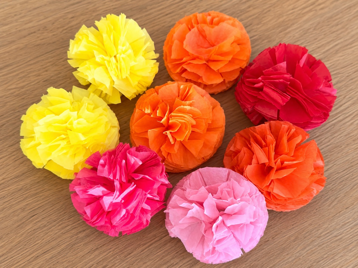 Finished tissue paper marigolds in yellow, orange, red and pink.