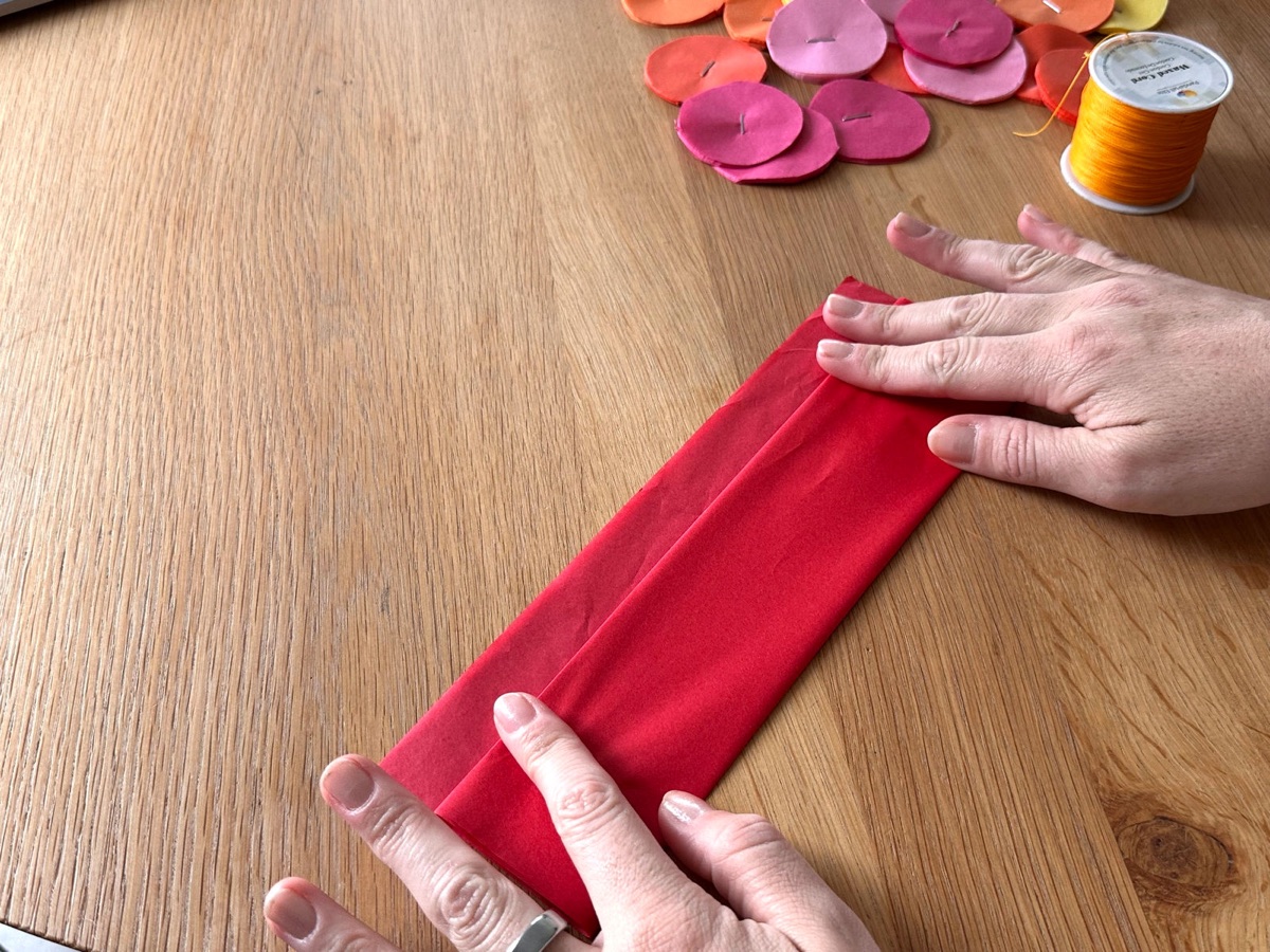 A stack of red tissue paper folded into a long strip.